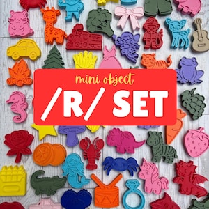 May include: A collection of colorful plastic cookie cutters in various shapes including animals, vehicles, food, and fantasy figures. The shapes are arranged in a grid pattern on a light wood surface, featuring a red overlay with the text mini object /R/ SET.