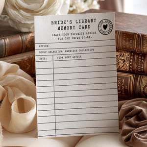 May include: A rectangular white card titled Bride's Library Memory Card with black text and lines. It features fields for Author, Shelf Selection: Marriage Collection, Date, and Your Best Advice, plus a circular stamp with a heart and text.