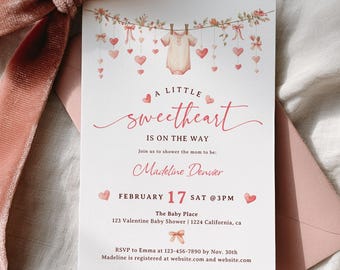 May include: A pink baby shower invitation with the text "A Little Sweetheart Is On The Way." The invitation features a baby onesie, hearts, and floral decorations. A pink envelope and a velvet ribbon are also visible in the image.