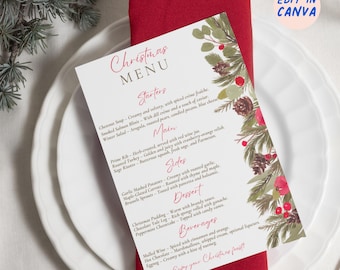 May include: A Christmas menu card with a festive design, featuring a red napkin and white plates. The menu card has a watercolor illustration of pine branches, berries, and pinecones. The menu includes starters, main courses, sides, dessert, and beverages.