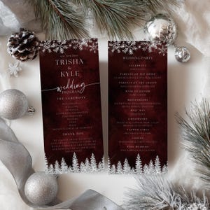 May include: Burgundy wedding program with silver snowflake and tree accents. The program includes the names Trisha & Kyle, wedding details, and the wedding party. The text is in a white, elegant font.