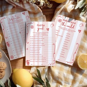 Puede incluir: Tres tarjetas de juegos para baby shower con rayas rosas y blancas, texto rojo e ilustraciones. Los juegos incluyen "Baby Name Race", "Find the Guest" y "Baby Around the World". Limones y galletas en el fondo.