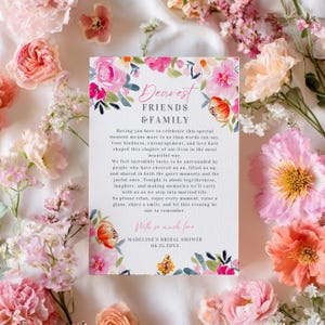 Può includere: Un invito a nozze floreale con il testo "Dearest Friends & Family". L'invito è circondato da fiori rosa e pesca. Il testo include un messaggio sull'unione e la creazione di ricordi.