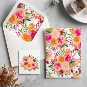 May include: A stationery set comprising a white envelope with a floral lining, a small square card, and a rectangular card. The floral design features pink, orange, and peach roses with green leaves on a white background. The set is displayed on a marble surface.