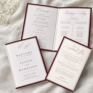 May include: A set of wedding stationery featuring a folded program and two cards with deep burgundy borders. The text includes the names Eloise and Harrison, the date May 24, 20XX, and details for the ceremony, wedding party, and a thank you note.