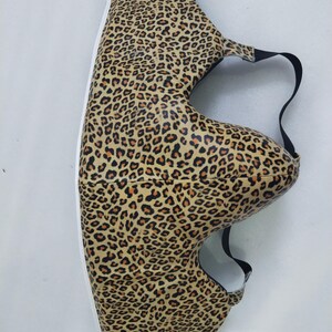 Puede incluir: Una funda de zapato con estampado de leopardo y una correa negra. La funda del zapato tiene una suela blanca y est&aacute; cubierta con un patr&oacute;n de manchas marrones y beige. La funda est&aacute; dise&ntilde;ada para proteger los zapatos.