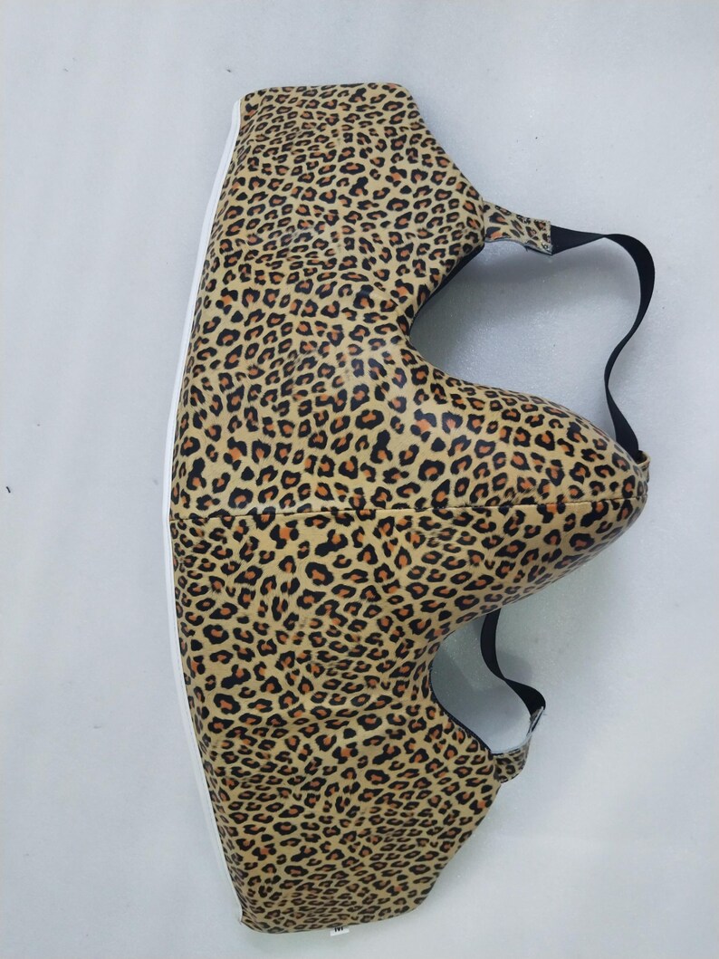Puede incluir: Una funda de zapato con estampado de leopardo y una correa negra. La funda del zapato tiene una suela blanca y est&aacute; cubierta con un patr&oacute;n de manchas marrones y beige. La funda est&aacute; dise&ntilde;ada para proteger los zapatos.