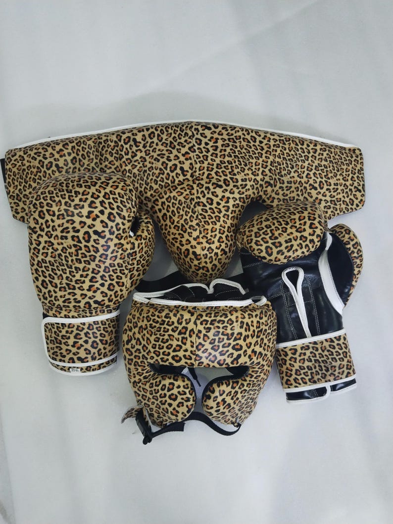 Puede incluir: Un conjunto de boxeo con estampado de leopardo. El conjunto incluye guantes de boxeo, un protector de cabeza y un protector de ingle. Los guantes tienen detalles en blanco y negro. El conjunto est&aacute; dise&ntilde;ado para la protecci&oacute;n durante el entrenamiento y los combates de boxeo.