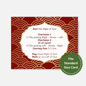 May include: A red and gold card with text detailing game instructions. The card features a decorative pattern and a central, cream-colored shape containing the rules. A green circular sticker indicates the card fits a standard size.