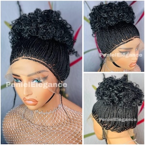 May include: A black braided wig with a curly bun on top. The wig is made with small braids and is styled in a high bun. The wig is on a mannequin head and has a lace front.