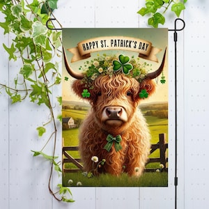 May include: A garden flag featuring a brown and white Highland cow with a green shamrock wreath around its head. The flag has the text "Happy St. Patrick's Day" on it.