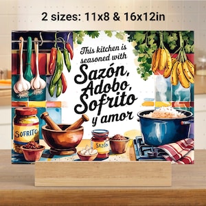 May include: A colorful kitchen cutting board with a watercolor design featuring a mortar and pestle, spices, and bananas. The text on the board reads "This kitchen is seasoned with Sazón, Adobo, Sofrito y amor". Available in two sizes: 11x8 inches and 16x12 inches.