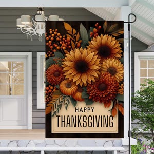 May include: A decorative Thanksgiving garden flag featuring a floral arrangement of sunflowers, mums, pumpkins, and berries in shades of orange and brown. The flag has the words "HAPPY THANKSGIVING" in a cream-colored banner.