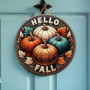 May include: Circular wooden sign featuring the text "HELLO FALL" and four pumpkins in orange, white, and teal. The sign is decorated with autumn leaves and hangs on a blue door.