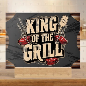 May include: A black cutting board with a white and red graphic that says "King of the Grill". The graphic includes a spatula, skewers, and a steak.