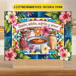 May include: A decorative cutting board featuring a colorful design with the text "Sazón, adobo, sofrito y amor." The design includes flowers, leaves, and jars. The cutting board is 16 x 12 inches and 11 x 8 inches.