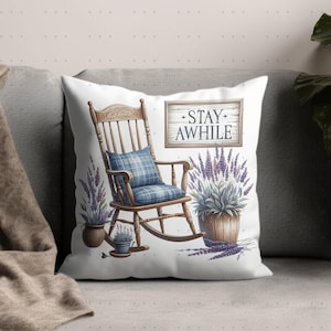 May include: White throw pillow with a rocking chair, lavender plants, and a sign that says "Stay Awhile".