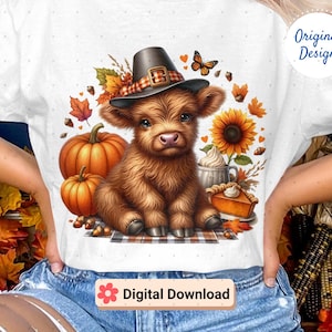 May include: White t-shirt featuring a brown Highland calf wearing a pilgrim hat, surrounded by pumpkins, sunflowers, and autumn leaves. A butterfly and pie complete the fall-themed design. The words "Original Design" and "Digital Download" are also visible.