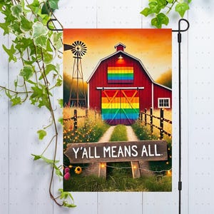 May include: A garden flag with a red barn with a rainbow door and a sign that says "Y'all Means All". The barn is set against a sunset sky with a windmill in the background.