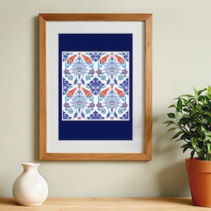 May include: A framed print featuring a detailed floral pattern in shades of blue, red, and white. The artwork is set against a dark blue background and framed in a light brown wooden frame. The print is displayed on a wooden surface.