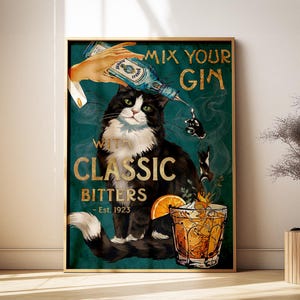 May include: A framed vintage-style poster featuring a black and white cat with green eyes. The poster has text that reads "Mix Your Gin With Classic Bitters - Est. 1923". A hand pours gin into a cocktail glass with an orange slice.