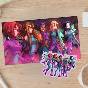 May include: A colorful illustration featuring six female characters with wings, in shades of purple, teal, and pink. A smaller sticker with the same characters is also visible. The artwork is on a wooden surface.