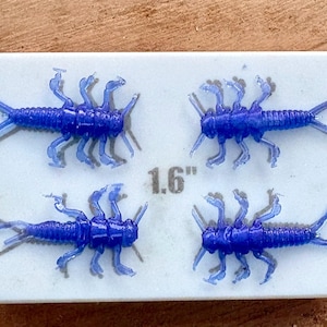 May include: Four blue rubber fly fishing lures, each measuring 1.6 inches long, are displayed on a white surface. The lures are designed to resemble aquatic insects.