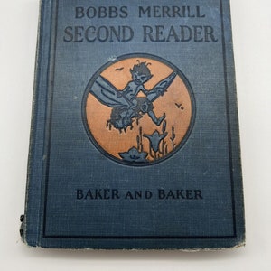 Puede incluir: Un libro azul con el título "Bobbs Merrill Second Reader" y el autor "Baker and Baker". La portada presenta una ilustración de un niño montando una libélula.
