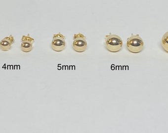 Op de afbeelding: Een verzameling gouden bolvormige oorstekers in verschillende maten: 3 mm, 4 mm, 5 mm, 6 mm en 8 mm. De oorbellen worden getoond op een witte ondergrond, waarbij hun gepolijste afwerking wordt getoond.