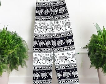 May include: White pants with a black and white elephant print. The pants have an elastic waistband and a drawstring.