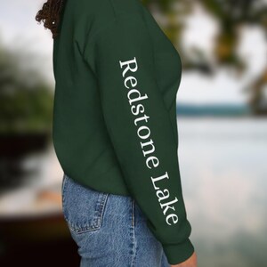 May include: A dark green sweatshirt with the text "Redstone Lake" printed in white on the left sleeve.
