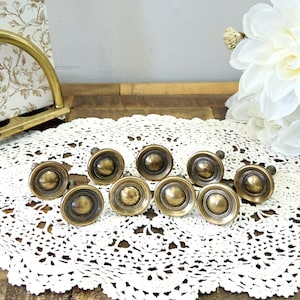 Peut inclure: Une tasse en céramique blanche avec une anse noire et le texte "But First, Coffee" dans un style manuscrit. La tasse est posée sur une surface blanche. La tasse mesure environ 10 cm de haut.