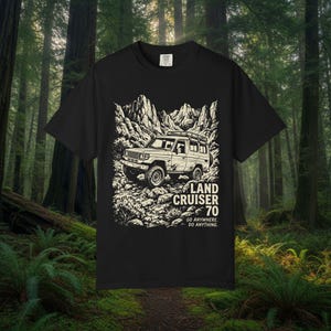 May include: Black t-shirt with a white illustration of a Land Cruiser 70 off-road vehicle set against a mountain backdrop. The text "LAND CRUISER 70" and "GO ANYWHERE. DO ANYTHING." are below the vehicle.