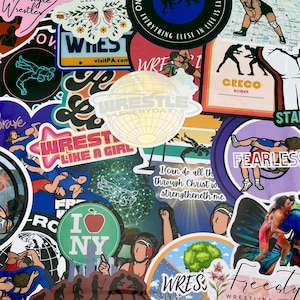 May include: A collection of colorful wrestling-themed stickers with various designs and slogans, including "Wrestle Like a Girl", "Fearless", and "Wrestle Everyday".