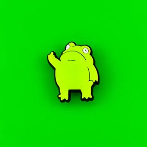 May include: A lime green frog-shaped sticker with a black outline, giving the middle finger. The frog has large, round eyes and is set against a bright green background. This sticker is a fun, expressive accessory.
