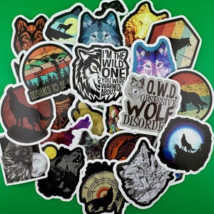 May include: A collection of colorful wolf-themed stickers with various designs, including a wolf howling at the moon, a wolf with the text "I'm the wild one you were warned about", and a wolf with the text "O.W.D. Obsessive Wolf Disorder".