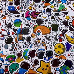 May include: A collection of colorful astronaut-themed stickers. The stickers feature astronauts, rockets, planets, food, and other space-related graphics. The stickers are in various shapes and sizes, with a white border.