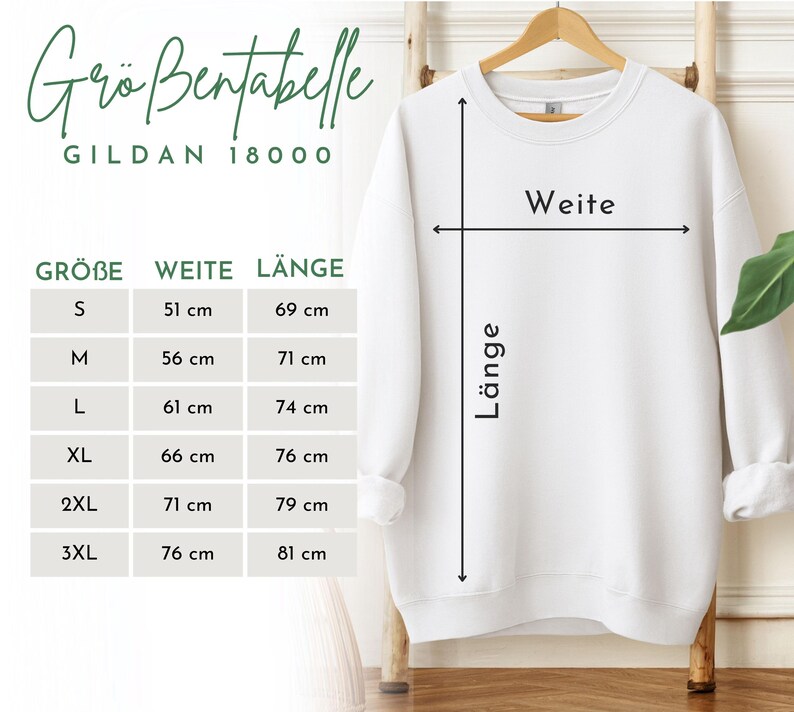 May include: A white Gildan 18000 sweatshirt displayed on a wooden hanger. The image includes a size chart with measurements in centimeters for width and length, ranging from size S to 3XL. The chart is labeled with German terms.