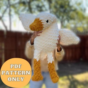 Könnte beinhalten: Eine große, handgefertigte, gehäkelte Gans in Weiß und Gelb. Die Gans hat einen weißen Körper, Flügel und Kopf mit einem gelben Schnabel und Füßen. Der Text "PDF PATTERN ONLY" befindet sich in einem gelben Kreis unten. Der Instagram-Handle "@isas.cositas" befindet sich oben rechts.