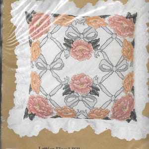 May include: A counted cross stitch kit for a floral pillow with a lattice design. The kit includes 14-count Aida cloth, cotton floss, graph, backing fabric, lace, and instructions. The finished size is 14 inches by 14 inches plus lace.