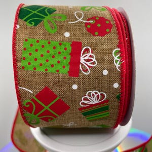 May include: A roll of brown burlap ribbon with a red, green, and white print of Christmas presents. The ribbon has a red edge.