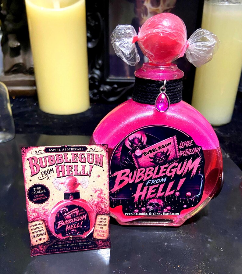 May include: A round glass bottle filled with bright pink liquid, topped with a pink sphere wrapped in clear plastic. A black collar features a pink teardrop charm. The label reads Bubblegum From Hell! with a devil illustration and skull graphic.