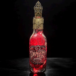 May include: A decorative glass bottle filled with a vibrant red liquid, labeled "Dragon Vein Potion." The bottle features a gold-colored stopper and decorative accents. The label has a dragon illustration. The bottle is illuminated from within, creating a glowing effect.
