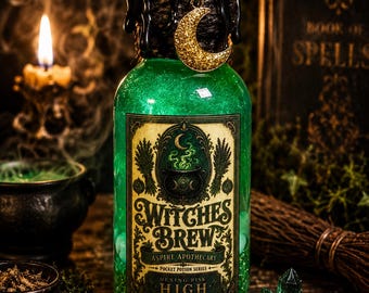 Puede incluir: Una botella de vidrio transparente llena de líquido verde con purpurina, rematada con cera negra y un dije de media luna dorada. La etiqueta dice Witches Brew, Aspire Apothecary, Pocket Potion Series, Hexing Risk High, con un caldero.