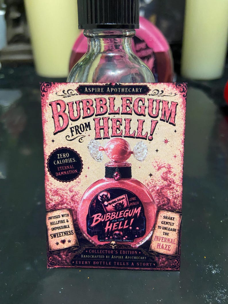May include: A clear glass bottle with a black cap featuring a rectangular label titled BUBBLEGUM FROM HELL! The label displays a pink liquid-filled bottle illustration, text reading ZERO CALORIES ETERNAL DAMNATION, and INFUSED WITH HELLFIRE & IMPOSSIBLE SWEETNESS.
