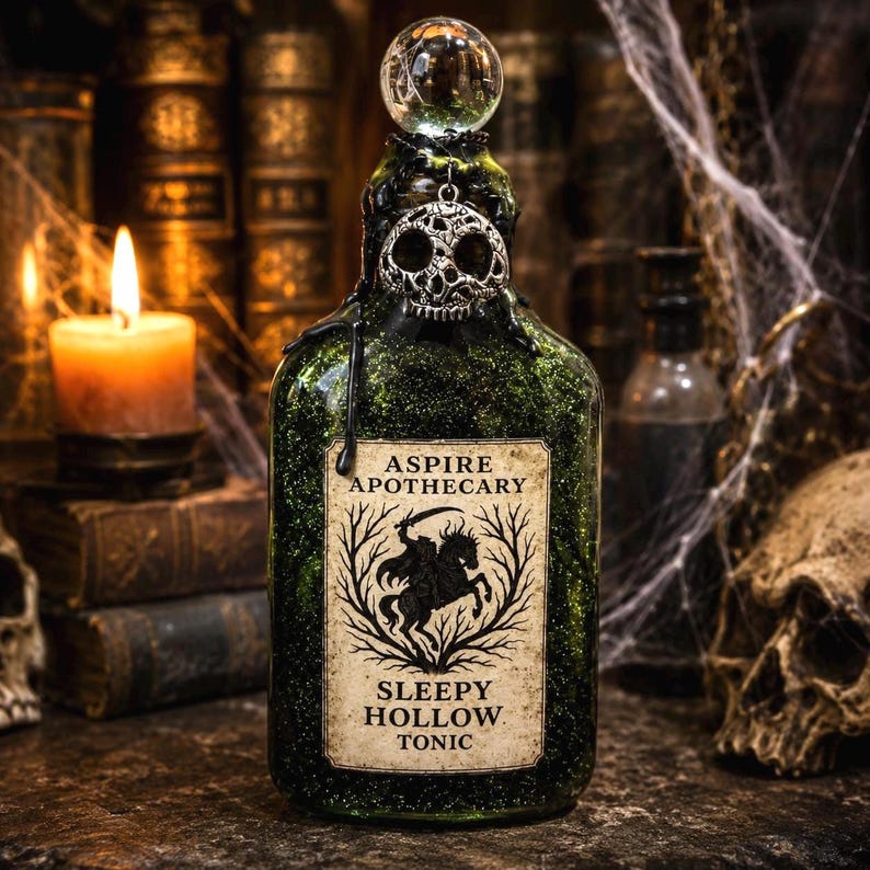 May include: A green glass bottle filled with glitter, topped with a clear sphere and a silver skull charm. The label reads ASPIRE APOTHECARY SLEEPY HOLLOW TONIC with an illustration of a headless horseman. Black wax drips from the bottle neck.