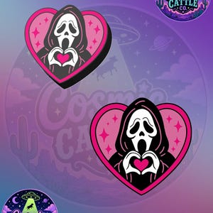 May include: Two heart-shaped stickers featuring a white ghost-like figure in a black hooded robe, making a heart shape with its hands around a pink heart. The background of each sticker is pink with small star accents. Two circular logos show a UFO.