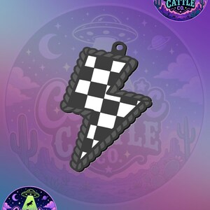 May include: A lightning bolt shaped pendant featuring a black and white checkered pattern. The edges of the bolt are framed by a dark gray rope-like border, and a small circular hole is positioned at the top for attachment to a chain or cord.