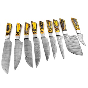 May include: Set of ten kitchen knives with black and yellow wooden handles. The blades are made of stainless steel with a damascus pattern.