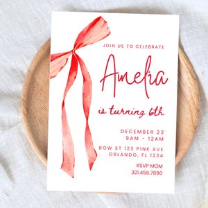 Könnte beinhalten: Eine weiße Einladungskarte mit einer roten Aquarell-Schleife. Der Text auf der Karte lautet "Join us to celebrate Amelia is turning 6th, December 23, 9AM - 12AM, BOW ST 123 PINK AVE, ORLANDO, FL 1234, RSVP MOM, 321.456.7890".
